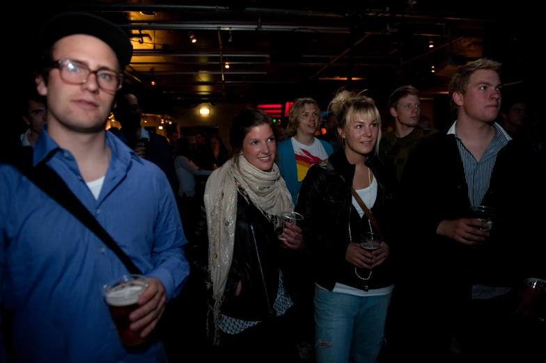 a group of people at a bar looking at soing