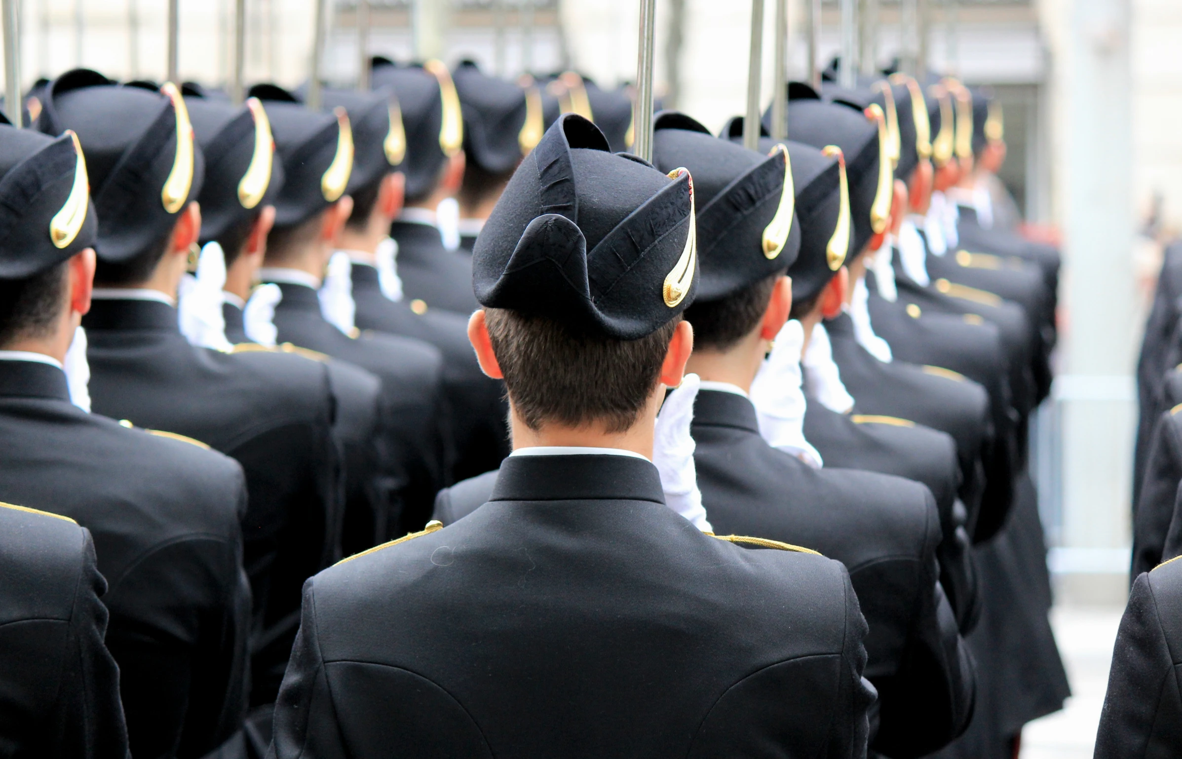 a man in uniform and cap looking out towards the crowd