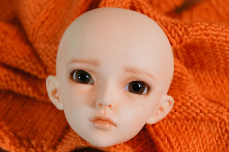 a close up of a baby doll with big eyes