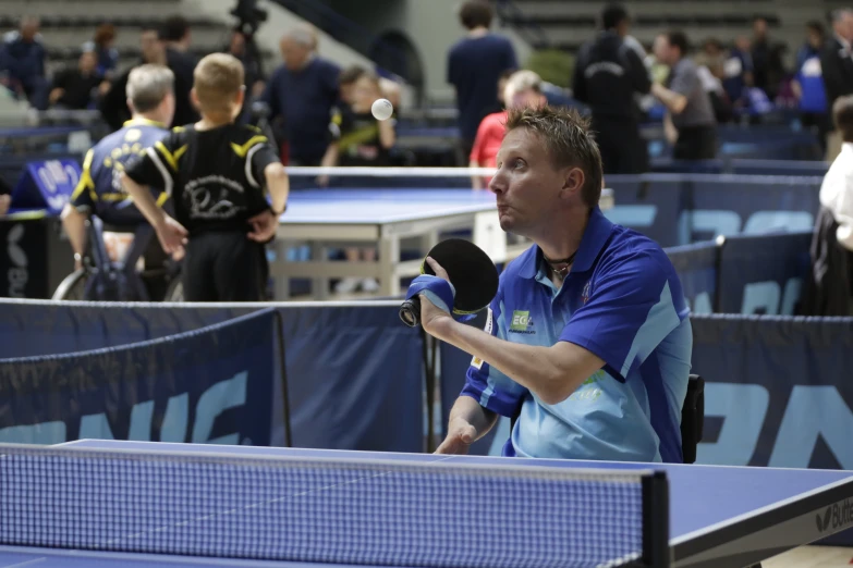 a man holding a racket on top of a table