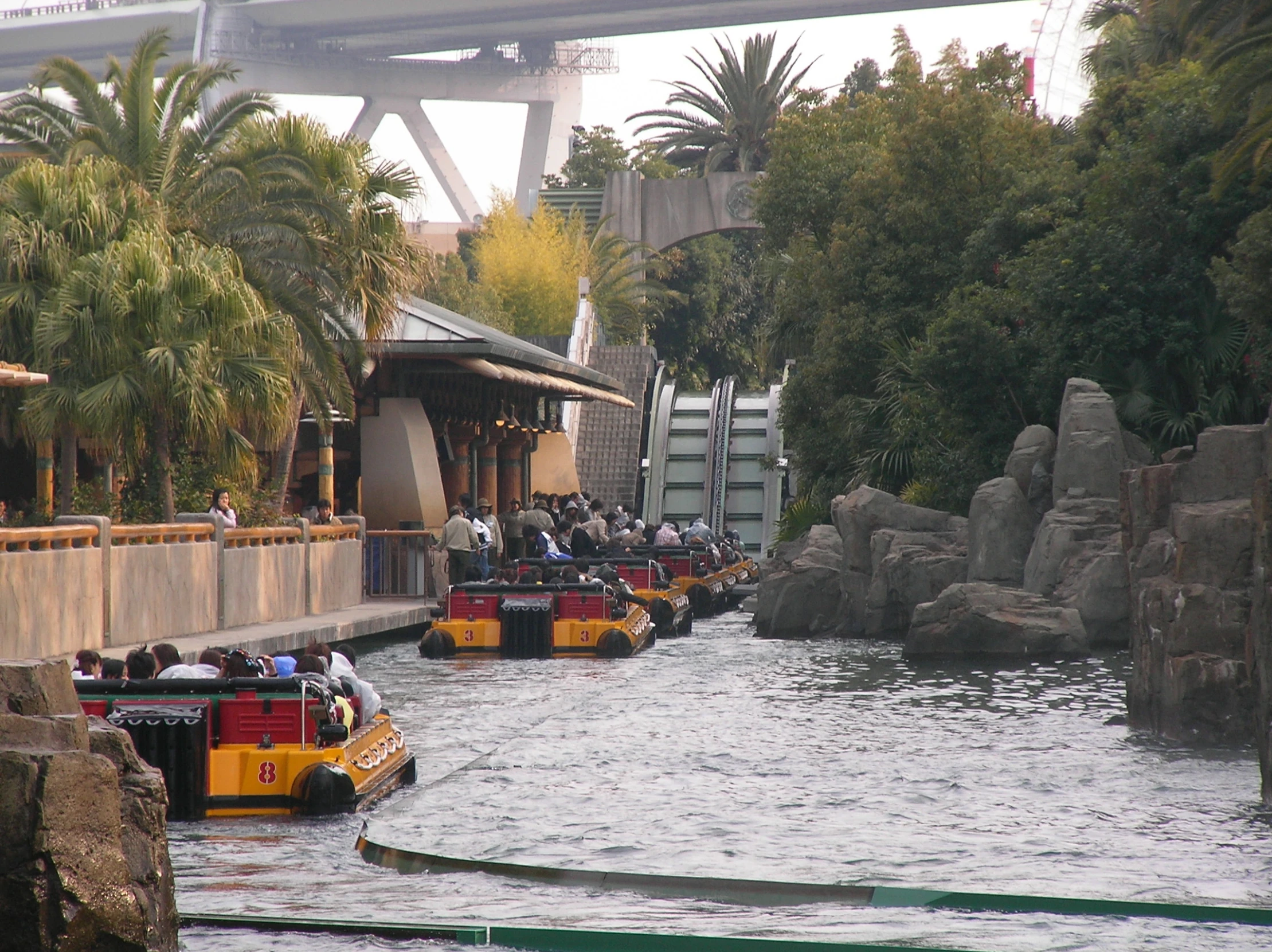 a couple of boats traveling down a river under a bridge