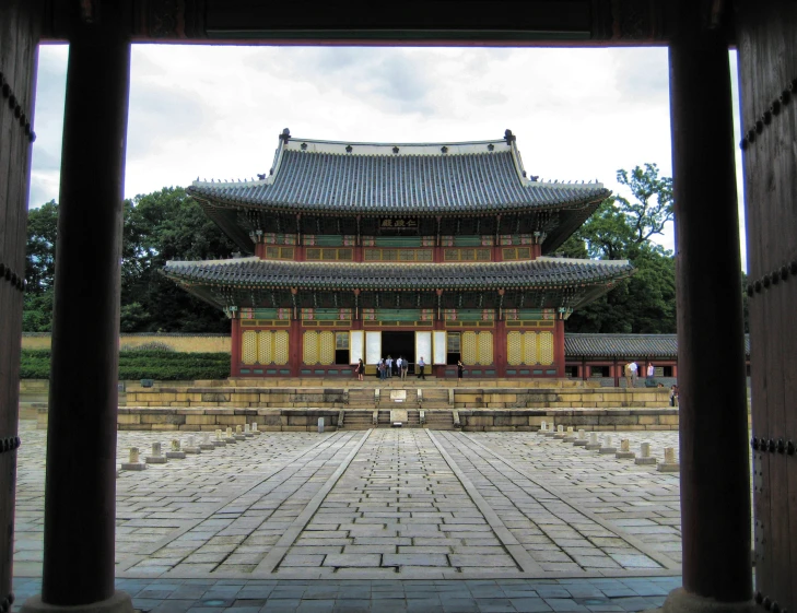an old asian structure stands in the middle of a courtyard