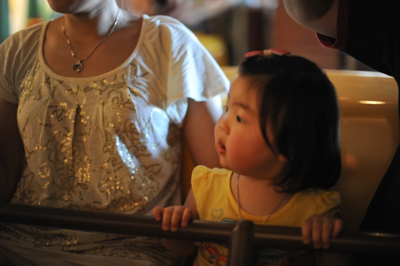 the baby is looking down at her mom's hand