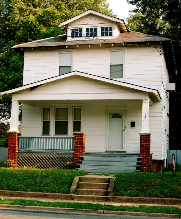 a white two story house on a small street corner