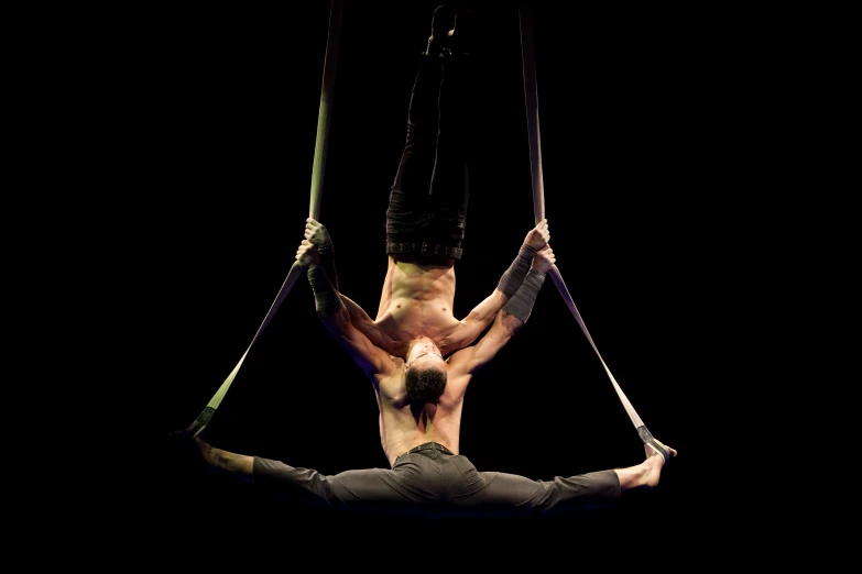 a male acrobatic on his handstand suspended