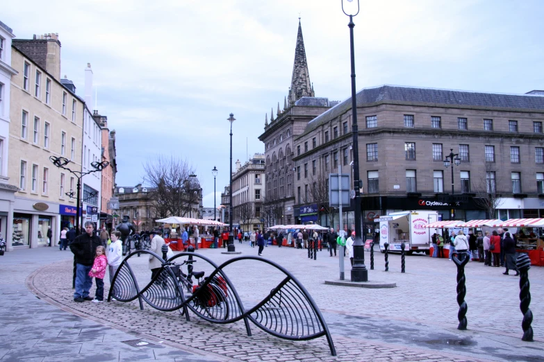 people standing around a group of art made to look like bicycles