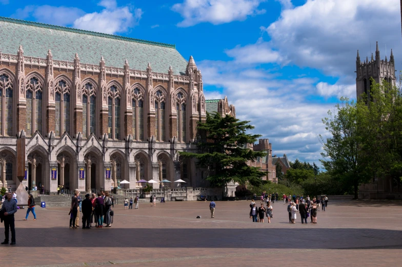 many people walking around in the courtyard of a building