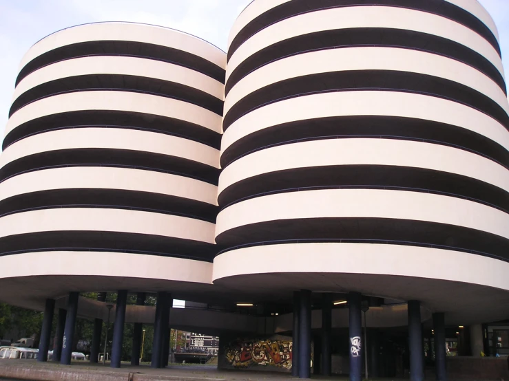 two black and white spirally shaped buildings in front of a street