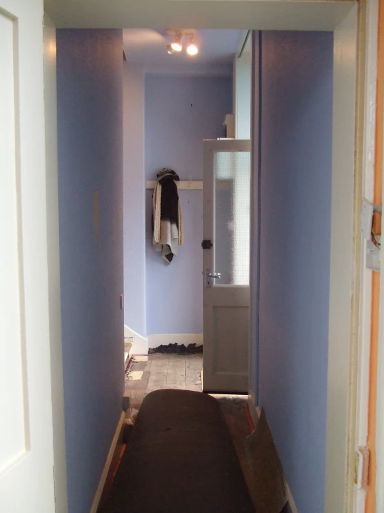 hallway with blue walls and white cabinets in a small home