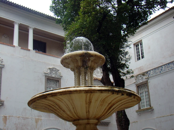 the small fountain is standing out in front of the building