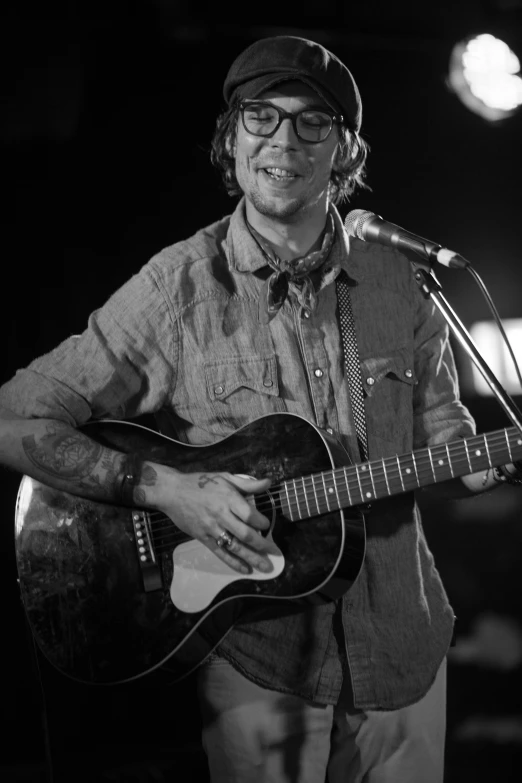 black and white po of man playing the guitar