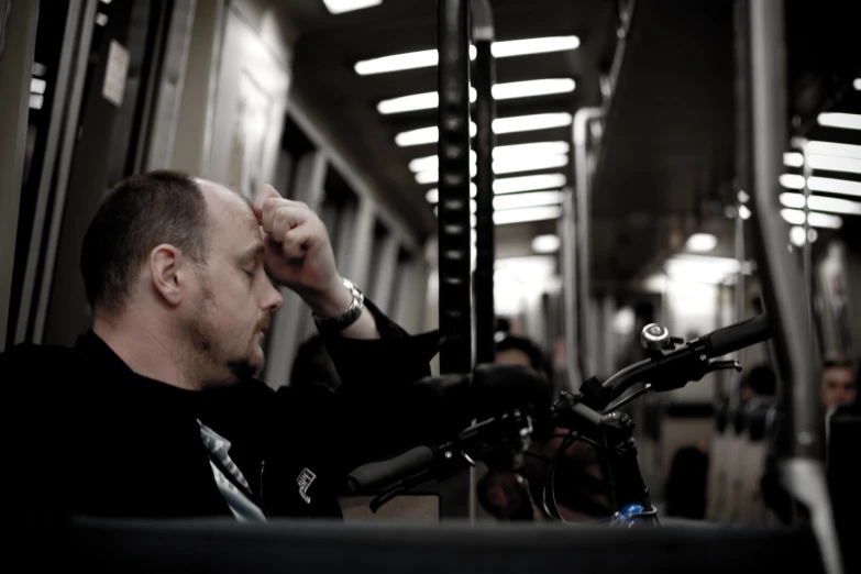 a man sitting on a train holding his head