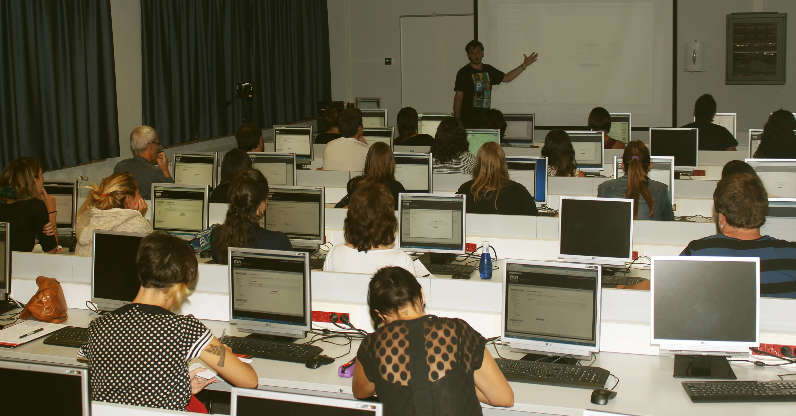 an office full of computer workers in a lecture hall