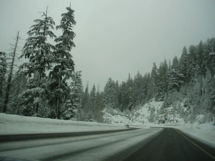 cars are traveling on a snowy road in the snow