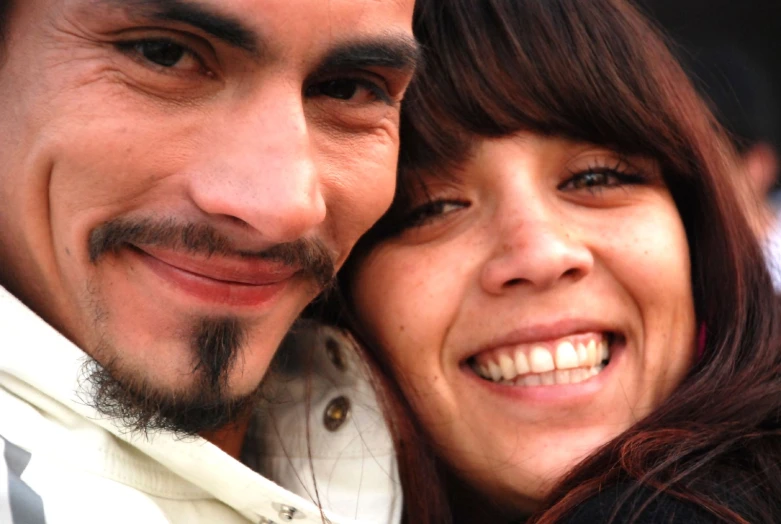 a man and woman smile at the camera