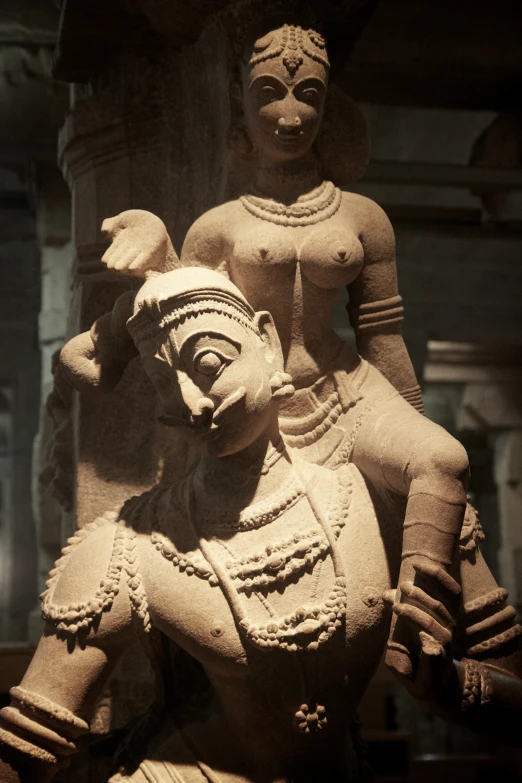 a statue of a woman and bird on a stone table