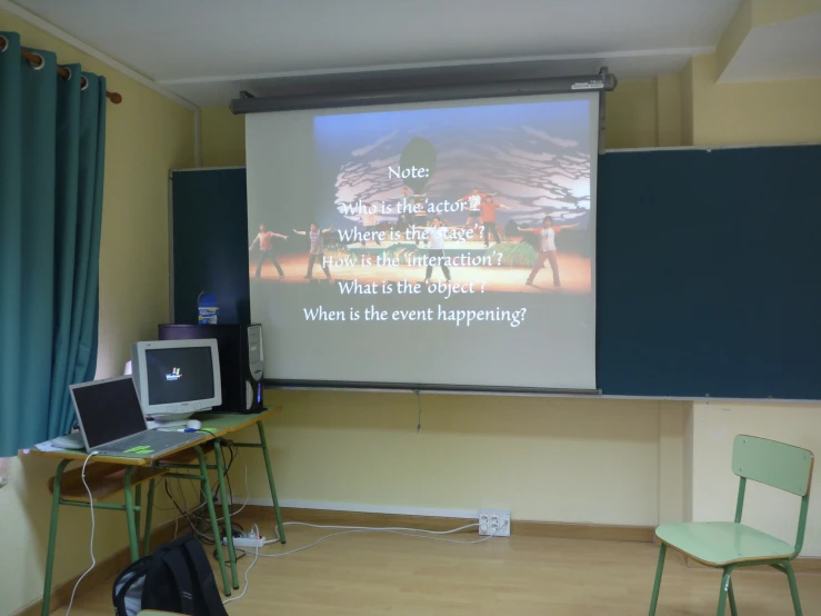 a computer lab with a projection screen and chairs