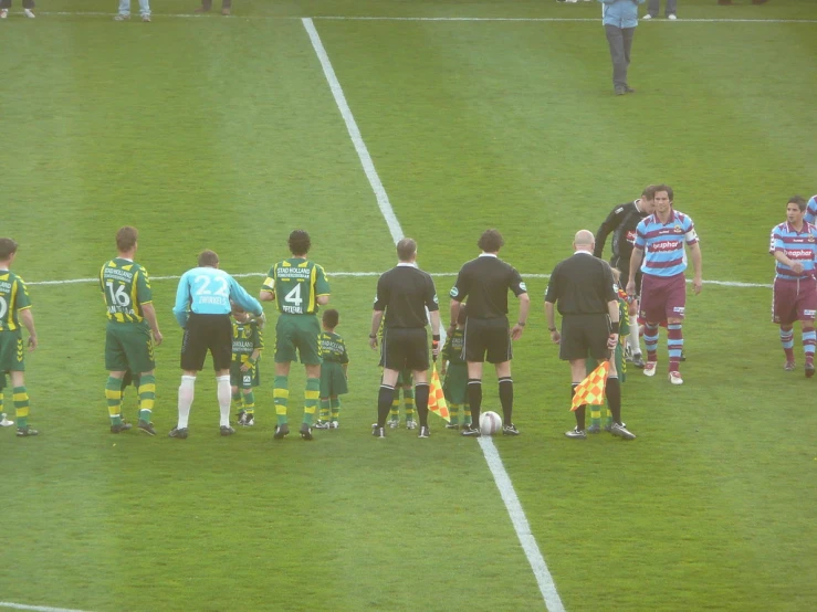 soccer players with referee at side of field on field