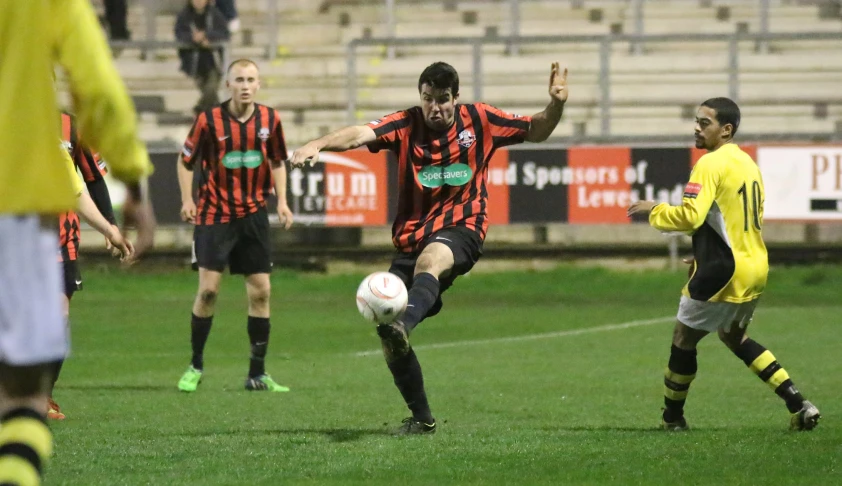 two men are playing soccer and one is kicking the ball