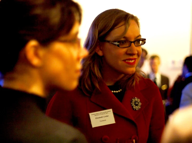 a woman is smiling as she talks with another lady