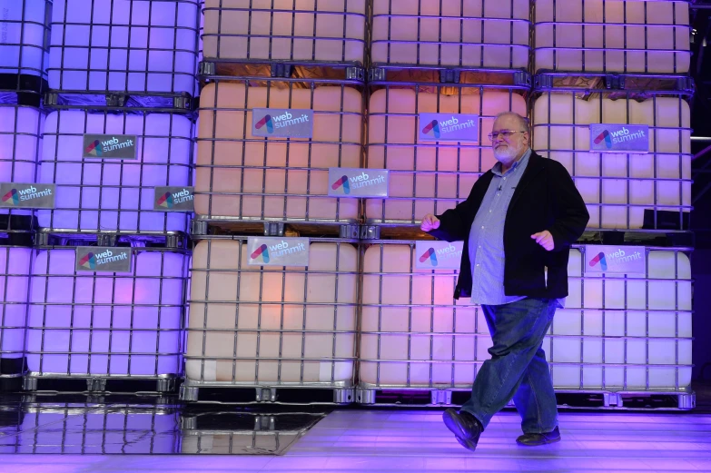 man walks on a stage with lots of crates