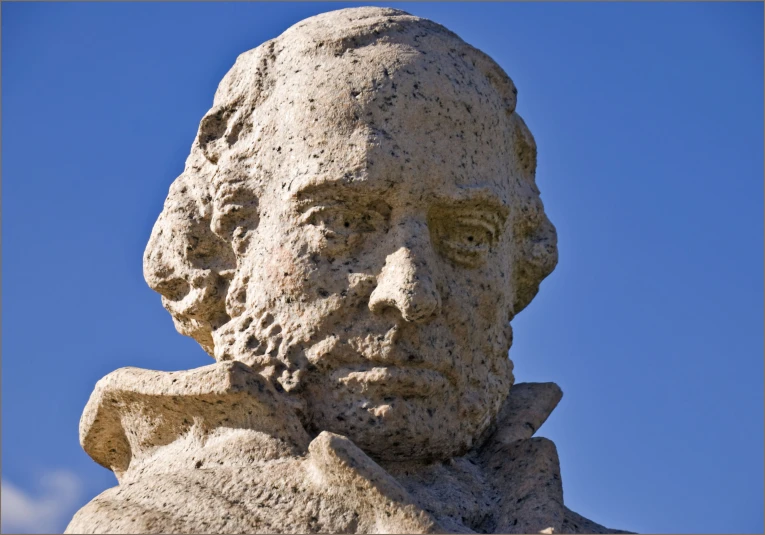 a statue of a man is shown against a blue sky