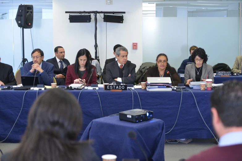 many people sitting at a table in front of microphones