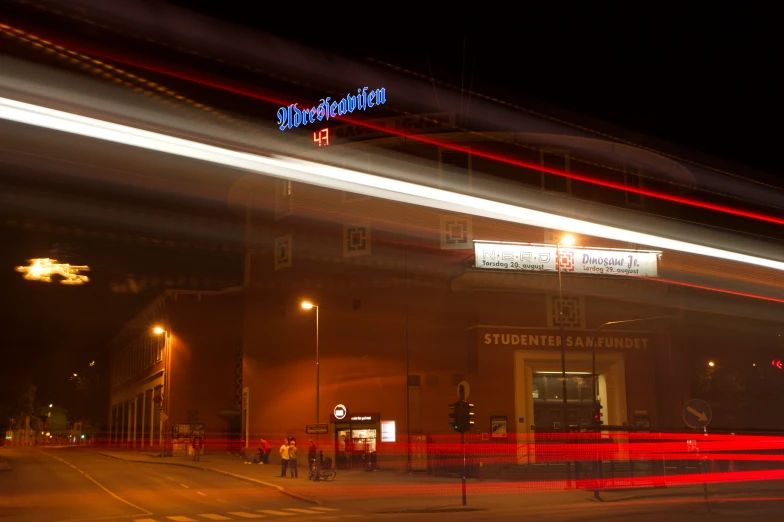 a light streaks over a city street with a sign on it