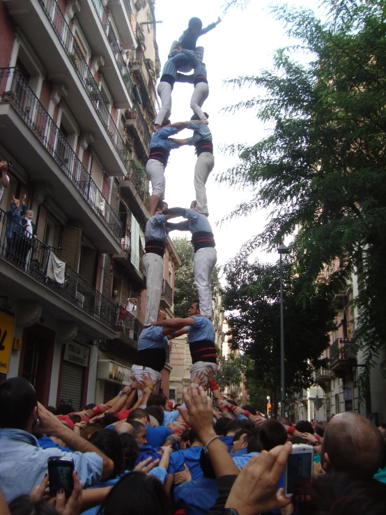 group of people with cameras are hanging upside down from the building