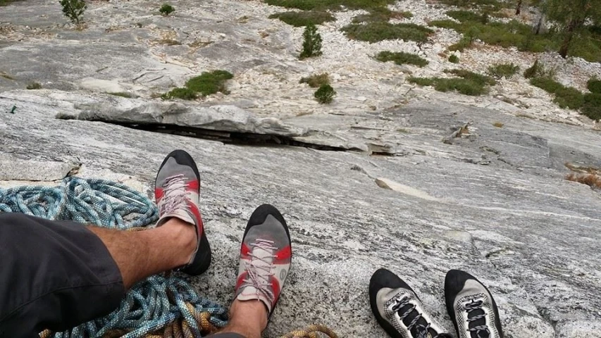 two feet on a rock next to a rope