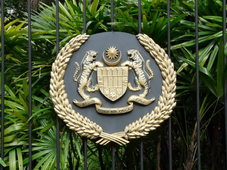 the emblem on a gate is depicting the coat of arms and shield of arms