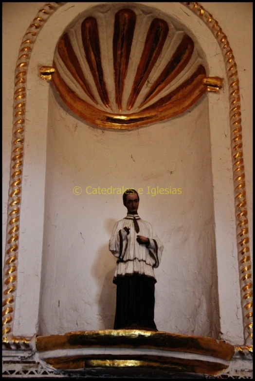 a statue of a priest in a white room