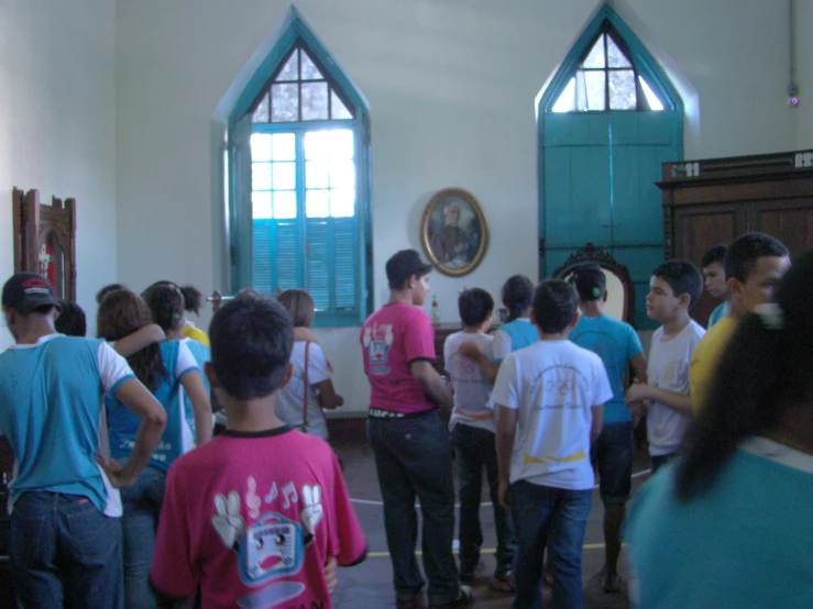 young people standing in front of a painting next to a wall