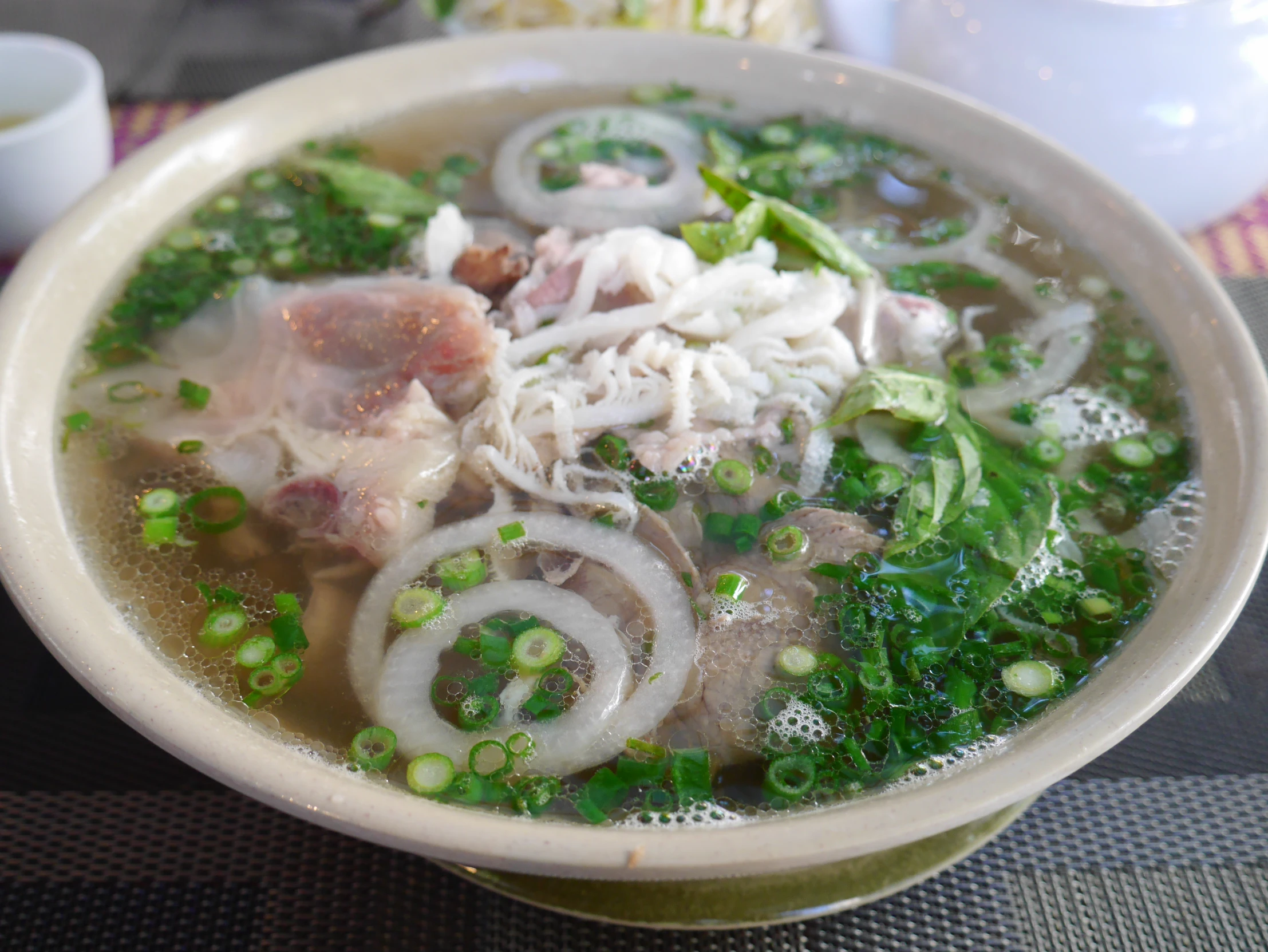 a bowl filled with meat and vegetables sits on a table