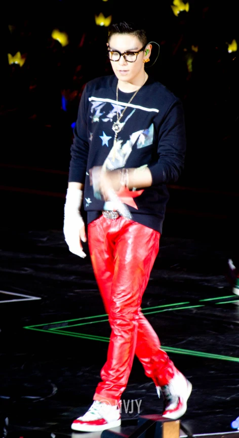 a person walking across a stage wearing shiny red pants