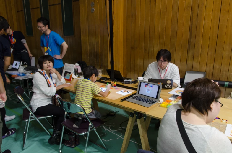 several people work on laptops at the same desk