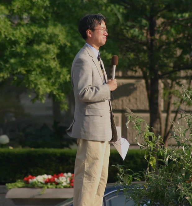 a man in a suit with a shovel and grass