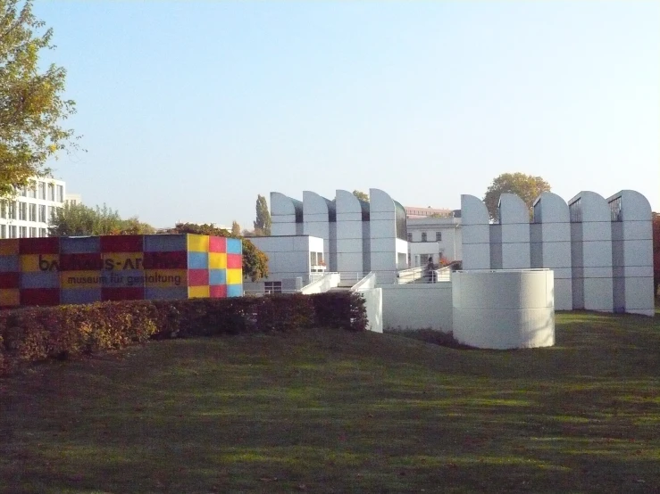 several cement squares sit on the grass near bushes