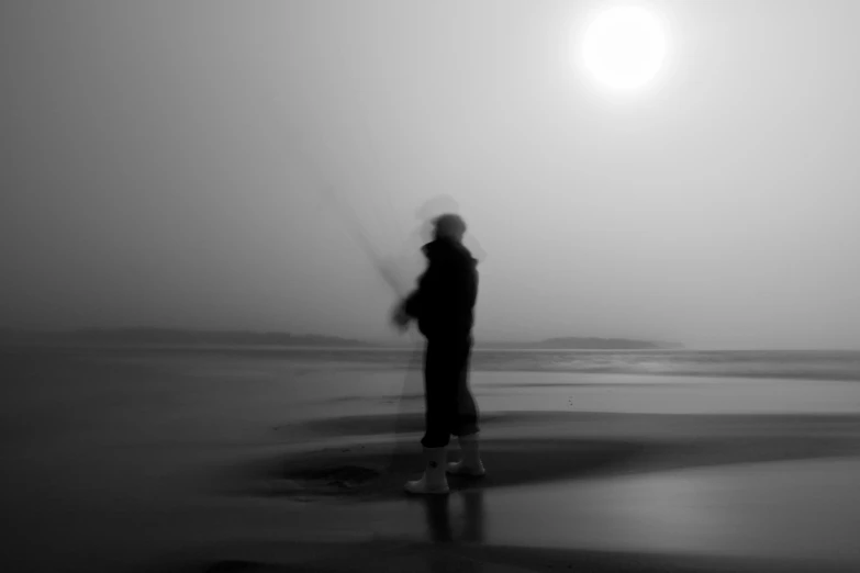 the person with a kite is standing in the fog