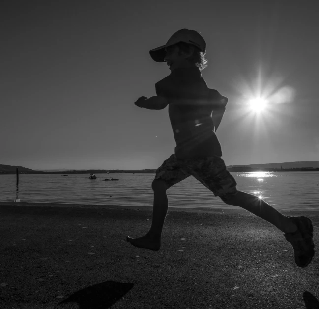 a person running across a beach during the day