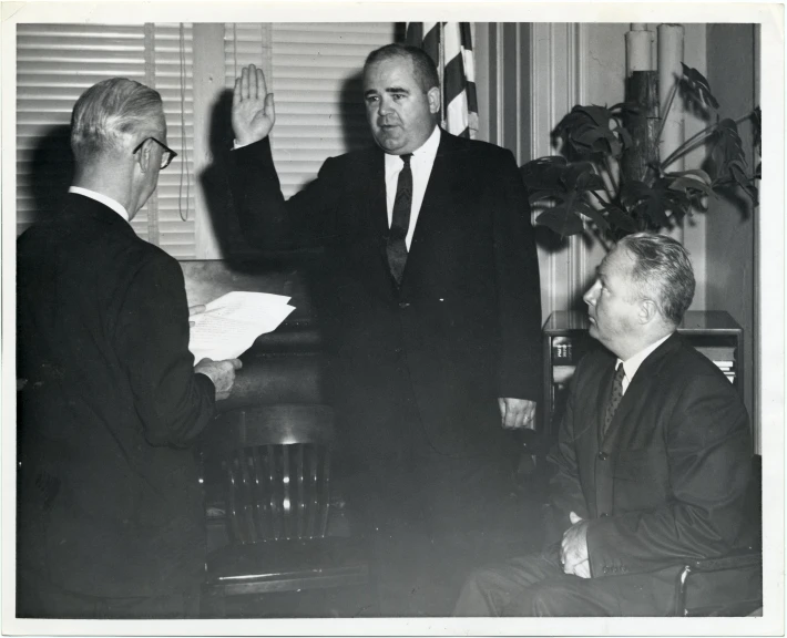 a black and white po shows men in suits