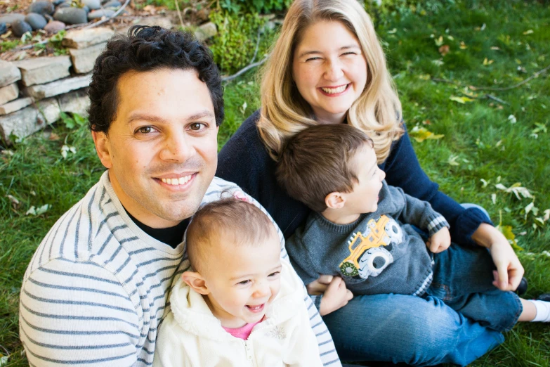 a family poses for a pograph with their toddler, little boy and girl