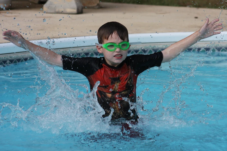  in sunglasses splashing through a swimming pool