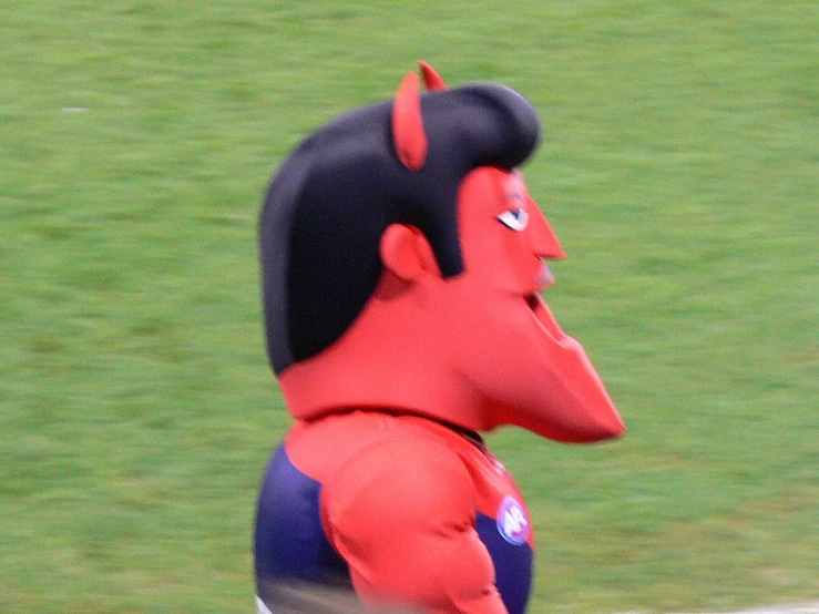 red devil mascot standing on a baseball field