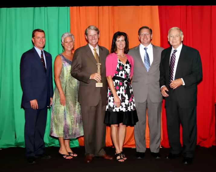 a group of people in front of colored curtains