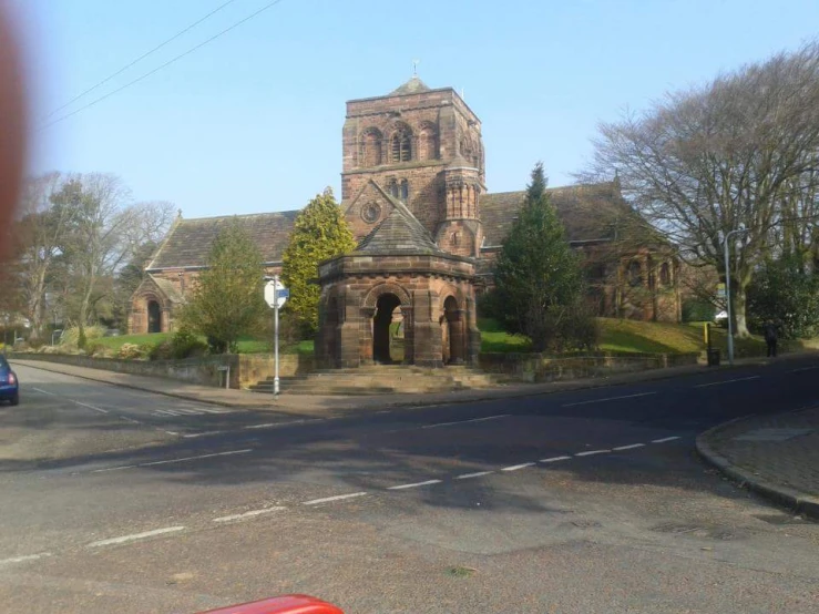 an old brick church sits next to a car