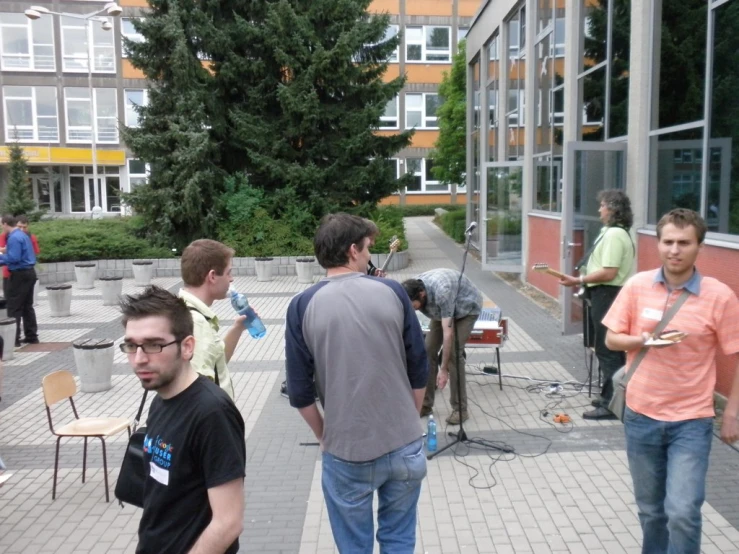 group of people walking down a sidewalk with a camera