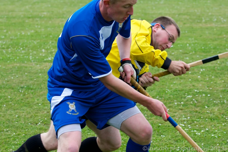 two men playing a game of frisbee in the grass