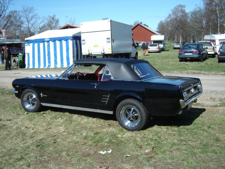 a black convertible car parked on top of a field