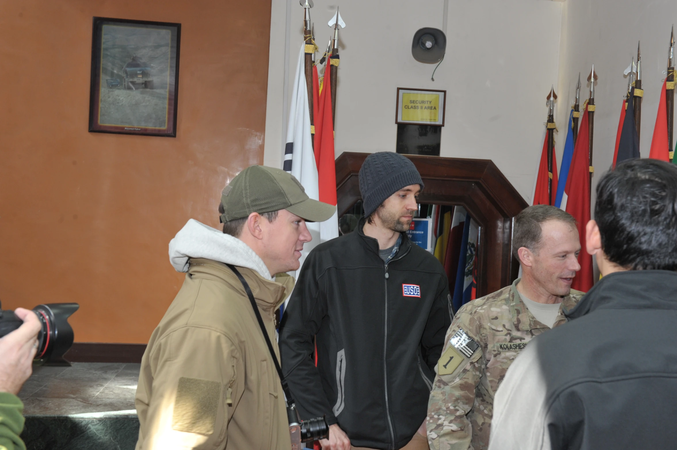 a group of men standing around a room with american flags